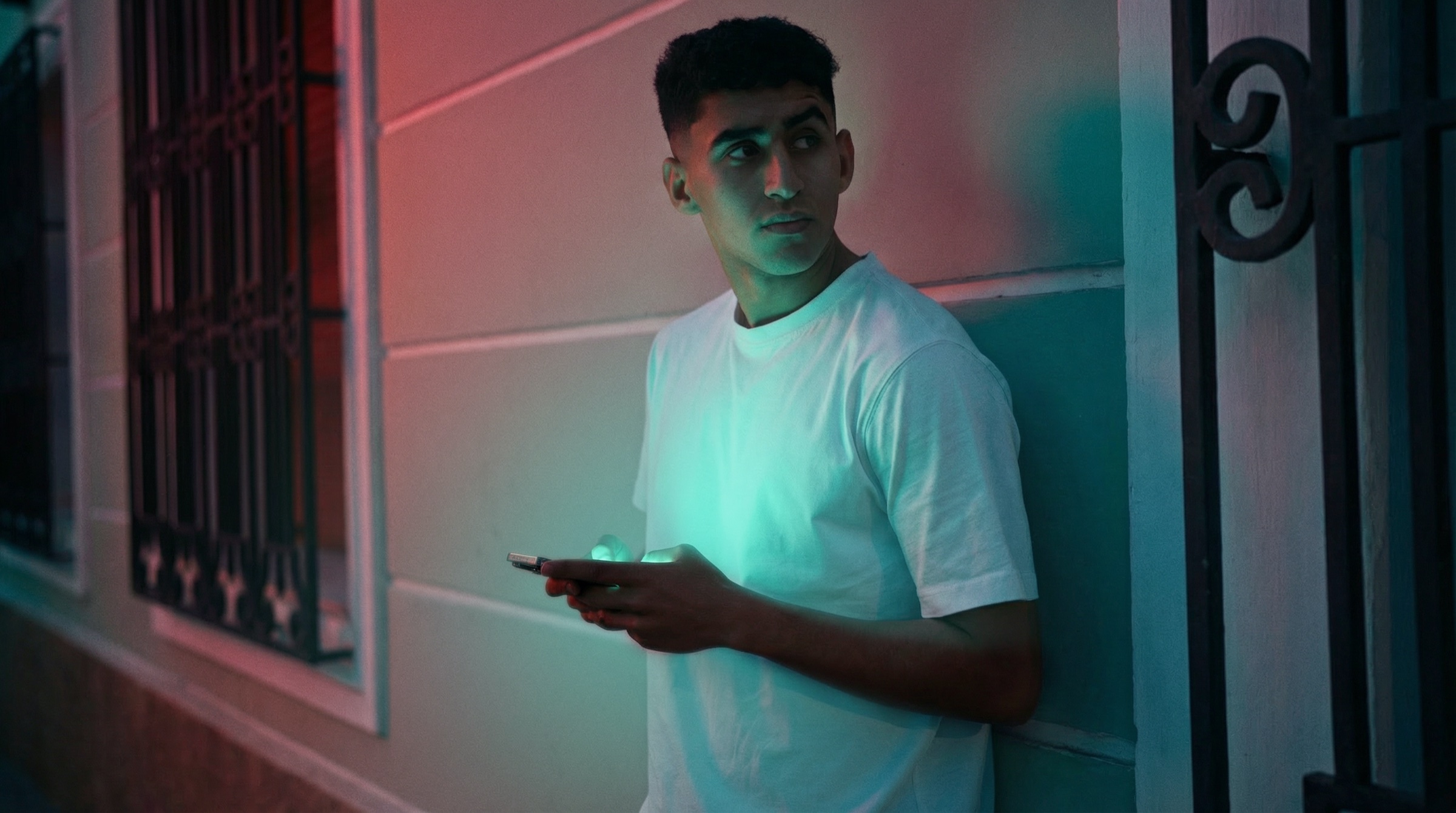 A housing seeker using his phone outside a building